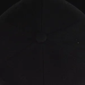 Close-up of black cotton twill baseball cap crown with six-panel stitching and top button