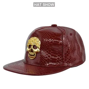Close-up of deep red faux crocodile leather snapback featuring a gold skull stud