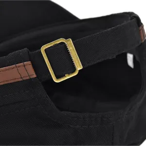 Detail of adjustable metal buckle and leather strap on a vintage black military cap