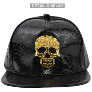 Detail view of black faux crocodile skin snapback hat with a gold rhinestone skull emblem