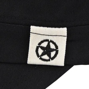 Dettaglio di una stella nera ricamata su una toppa crema con cuciture in twill di cotone