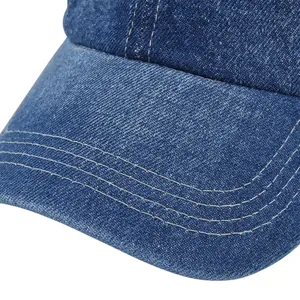 Detailed close-up of blue denim baseball cap with reinforced white stitching on the brim