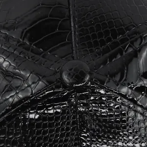 Macro shot of black glossy faux crocodile skin texture and top button on hip-hop cap
