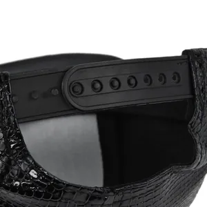 Detailed close-up of black crocodile embossed faux leather texture and plastic snapback closure