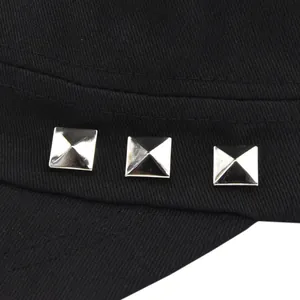 Detail of silver pyramid studs on black canvas military cap with neat stitching