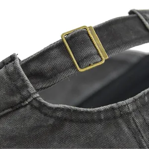 Detail of adjustable metal buckle and washed cotton strap on a charcoal military cap