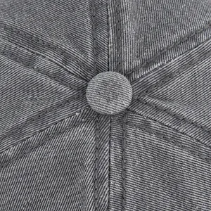 Dettaglio macro del bottone superiore e delle cuciture di questo cappello denim grigio