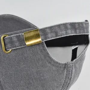 Dettaglio della fibbia in ottone regolabile su berretto da baseball in denim grigio lavato