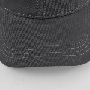 Detailed close-up of stitching on a dark grey cotton twill baseball cap brim