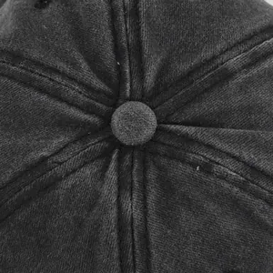 Dettaglio delle cuciture in cotone lavato e del bottone sulla parte superiore del berretto