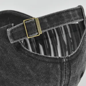 Détail de la boucle métallique réglable et texture délavée de la casquette baseball