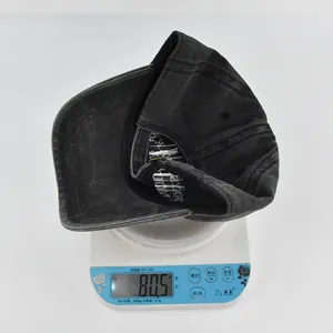 Dettaglio del leggero berretto da baseball vintage da 80,5g in cotone lavato su bilancia