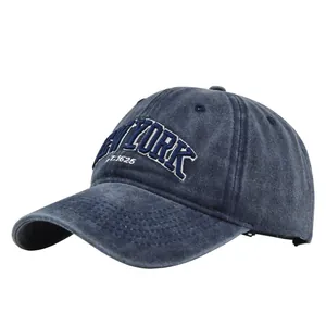 Detail of white 3D NEW YORK embroidery on washed navy blue denim baseball cap