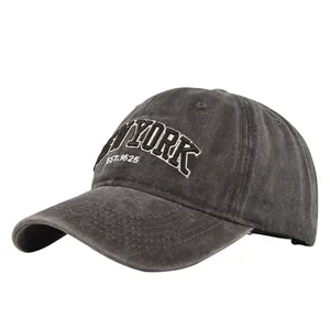 Detail of vintage washed grey baseball cap featuring white NEW YORK embroidery and curved brim