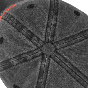 Vue détaillée du dessus d'une casquette délavée montrant coutures et broderie rouge