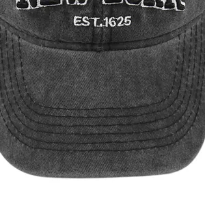 Close-up of white 1625 embroidery on washed grey cotton baseball cap with stitch details