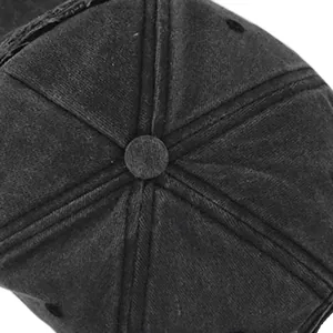 Dettaglio del bottone superiore e delle cuciture rinforzate su un cappellino in cotone nero