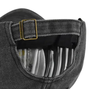 Dettaglio macro di cappello baseball in denim lavato con fibbia in ottone regolabile sul retro