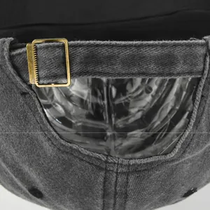 Detailed close-up of retro washed grey denim fabric and bronze metal adjustment buckle