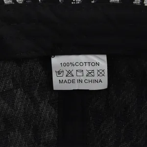 Detalle de la etiqueta de lavado de 100% algodón e instrucciones de cuidado de la gorra