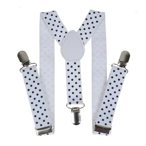 Detail of Y-back elastic suspenders featuring black polka dots and metal adjustment clips