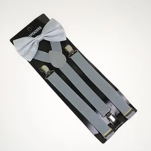 Close-up of light gray elastic suspenders with metal clips and a matching satin bow tie