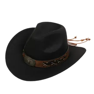 Dettaglio cappello cowboy nero con fascia in pelle, stemma a toro e nappe con perline
