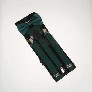 Detail of dark green suspenders and bowtie set with silver clips on black backing