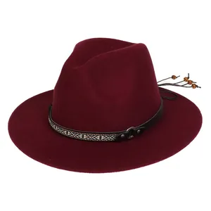 Detail of burgundy fedora hat with ethnic embroidery band and wooden bead tassels