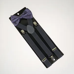 Detail of navy blue elastic suspenders with metal clips and a matching satin bowtie set