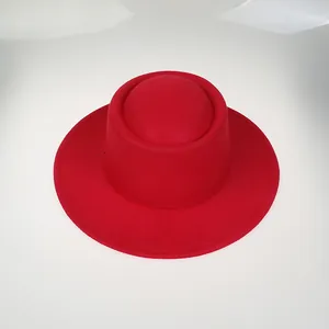 Top view of red wool felt flat top hat with wide brim and unique cylindrical crown shape