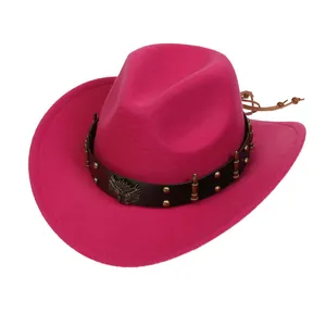 Detail of rose red cowboy hat featuring black leather band and metal eagle emblem