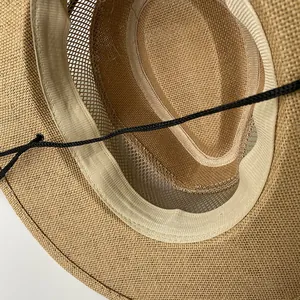 Detail of straw hat interior with breathable mesh top and adjustable black wind cord