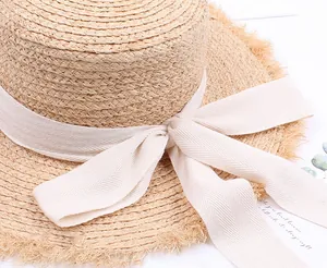 Close-up of elegant raffia straw hat texture with fringe edge and ribbon bow detail