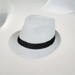 Détail d'un chapeau fedora en paille blanche avec texture tressée et ruban noir élégant