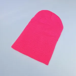 Close-up of vibrant neon pink beanie with detailed ribbed knit texture and soft yarn