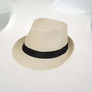 Détail du chapeau de paille crème avec ruban noir montrant la texture tressée