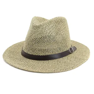 Detail of woven Panama straw hat texture with dark brown leather band and metal buckle