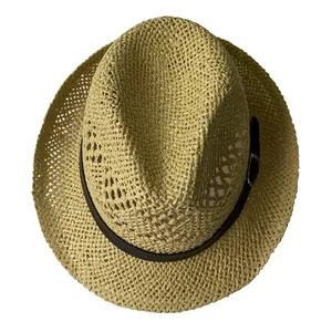 Detail view of woven straw fedora hat with a brown leather buckle strap for summer