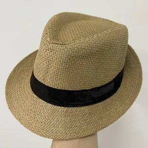 Détail d'un chapeau de paille léger avec ruban noir et texture tressée fine