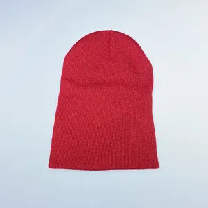 Close-up of red knit beanie showing flat-stitch texture and plain warm acrylic fabric