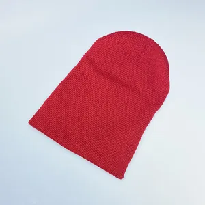Close-up of vibrant red knitted beanie showing fine ribbed texture and soft acrylic yarn