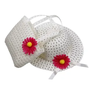Detailed view of kids' straw sun hat and matching handbag with pink floral accents