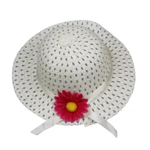 Close-up of white breathable straw sun hat with pink daisy flower and satin ribbon bow