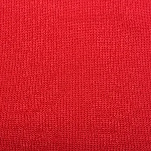 Close-up of red winter knit hat material showing detailed soft ribbing and texture