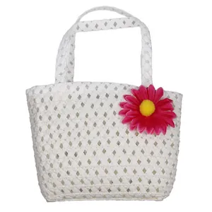 Detailed view of kids woven handbag with a pink daisy flower in white ivory finish