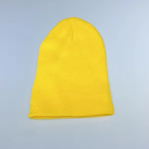 Detail shot of bright yellow knitted beanie featuring classic ribbed cuff texture
