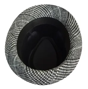 Dettaglio del cappello fedora a quadri bianco e nero con fascia interna e fodera interna