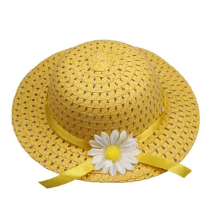 Detail of yellow straw hat with white daisy floral decor and satin ribbon for kids