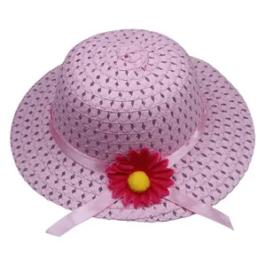 Close-up of pink woven kids straw hat with red sunflower and satin ribbon detail